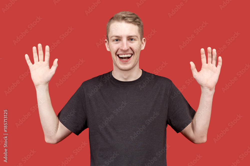 joyful happy young man raises his hands in the posture of 