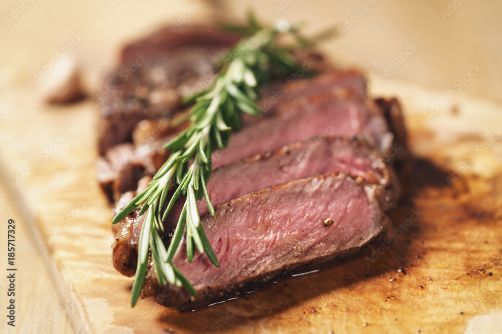 sliced rib eye steak on wood board