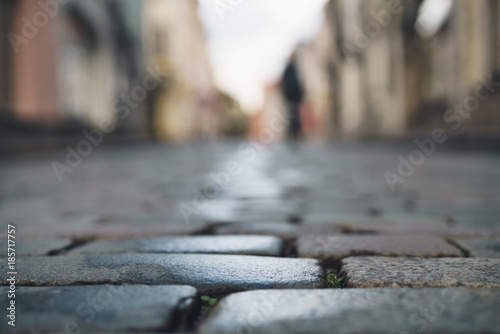 low angle closeup background of wet old pavement with blurred background