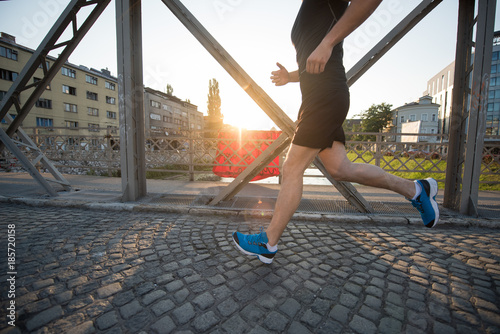 man jogging across the bridge at sunny morning