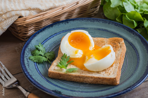 Soft boiled egg with toast on blue plate