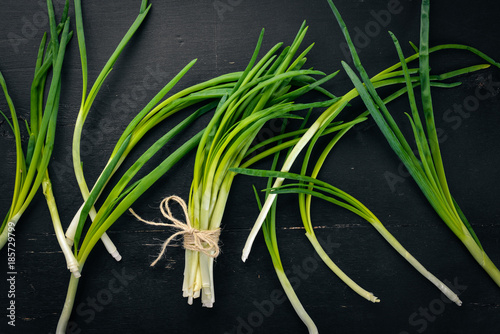 Fresh green onion on a wooden background. Top view. Free space for your text.