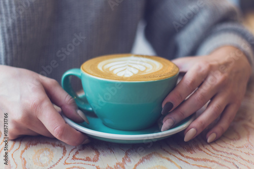 woman with a Cup of cappuccino in a cafe, closeup hands with a cup