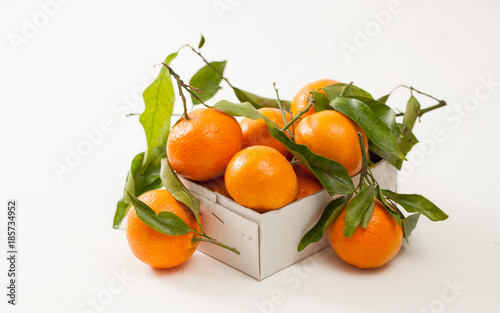 Fresh tangerines in a box on white background © ekramar