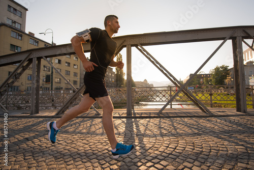 man jogging across the bridge at sunny morning