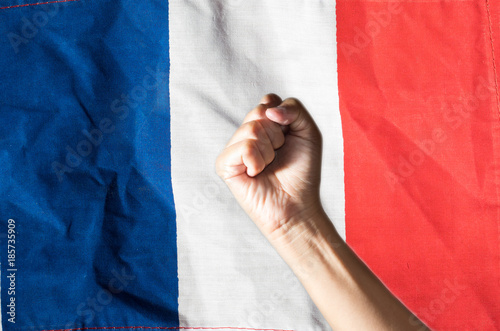 Hand clenched a fist and France National flag.