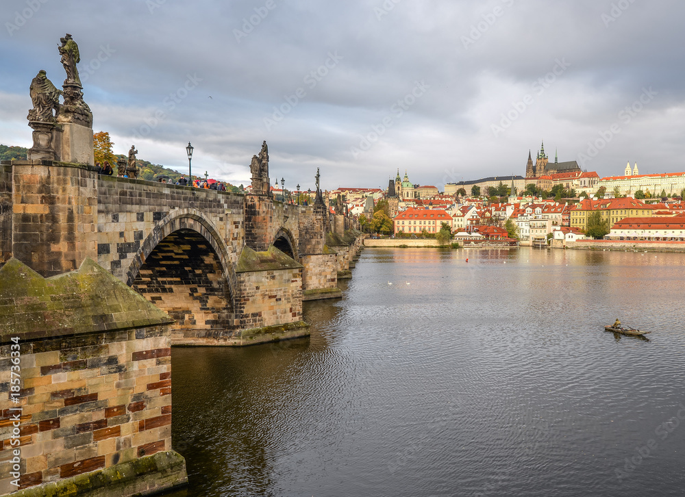 Prague, Czech Republic - October 13, 2017: Dramatic cloudy autumn view of Charles Bridge, Vltava river, St. Vitus Cathedral, Prague Castle and Old Town, Prague, Czech Republic. 