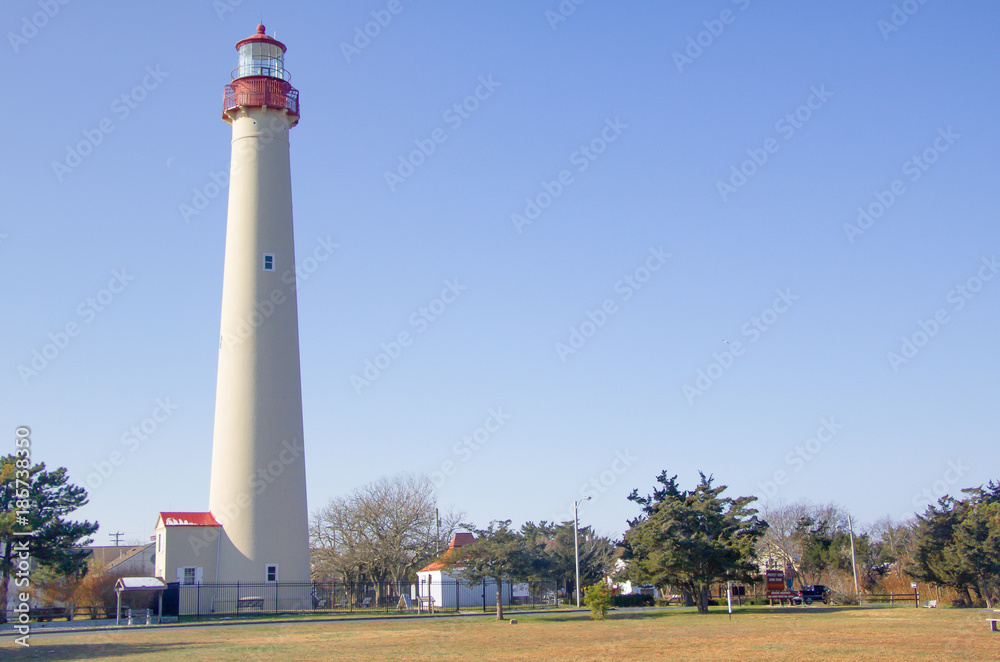 Exterior daytime stock photo of lighthouse at edge of field in Cape May New Jersey in Cape May County on winter December afternoon with blue cloudless sky in background