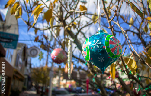 Exterior daytime shallow depth of field stock photo of colorful christmas ornaments hanging from tree in Clinton New Jersey, in Hunterdon County, on bright autumn day
