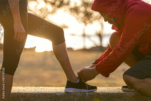 Bilde på lerret Runners couple tying running shoes to run banner