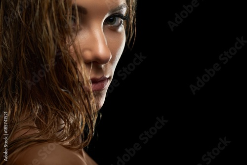 Close up cropped portrait of a gorgeous young confident fierce female model with wet hair and natural makeup copyspace beauty eyes eyelashes cosmetics smooth silky soft concept.
