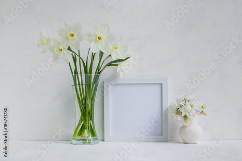 Fototapeta Naklejka Na Ścianę i Meble -  Mockup with a white frame and white daffodils