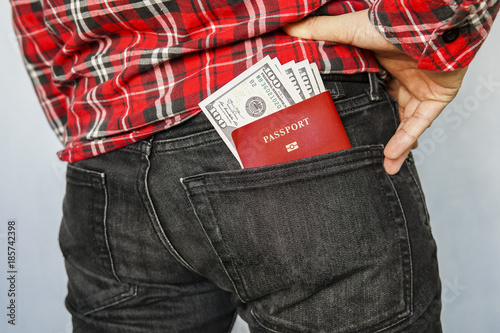 Passport in the back jeans pocket with American dollars. photo