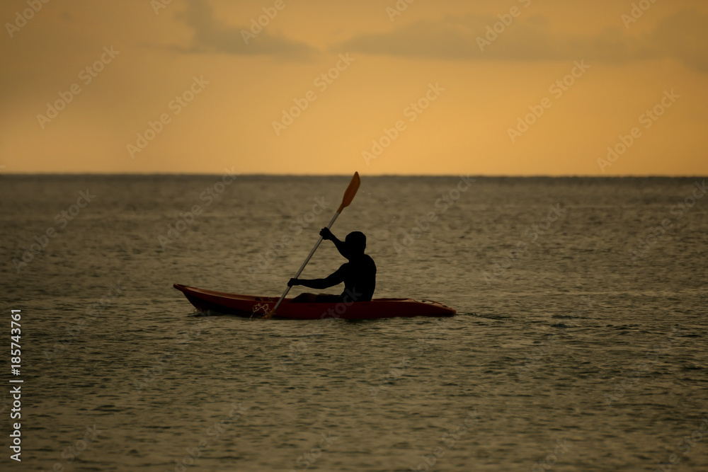 Naklejka premium Silhouette of man with paddle and Kayak sunset moment