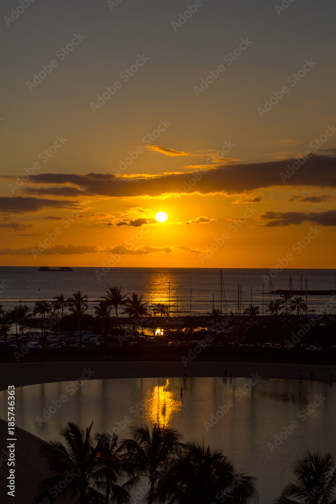 Tropical Sunset, Waikiki Beach, Honolulu, Hawaii with silhouette palm tress, sea and sand