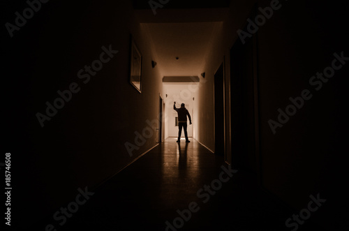 Dark corridor with cabinet doors and lights with silhouette of spooky horror man standing with different poses.