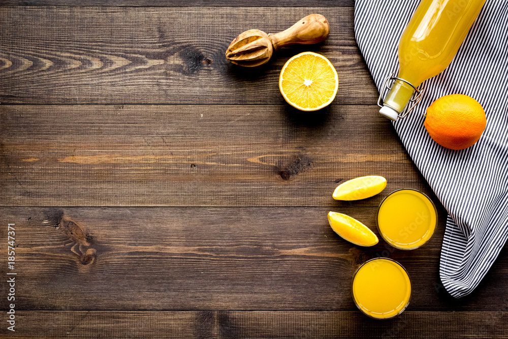 Squeeze juice from oranges. Juicer and slices of oranges on dark wooden background top view copyspace Squeeze juice from oranges. Juicer and slices of oranges on dark wooden background top view copyspace