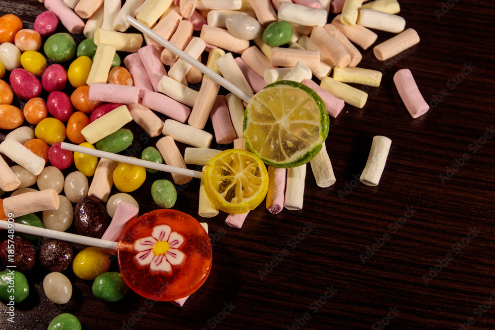 Colorful candies, lollipops and marshmallows on wooden table Colorful candies, lollipops and marshmallows on wooden table