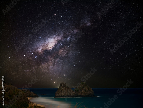 The Milky Way sets behind Morro Dois Irmaos (Two Brothers Hill), in the Island of Fernando de Noronha, Pernambuco, Brazil, photographed from the Boldro Fortress viewpoint © Marcelo