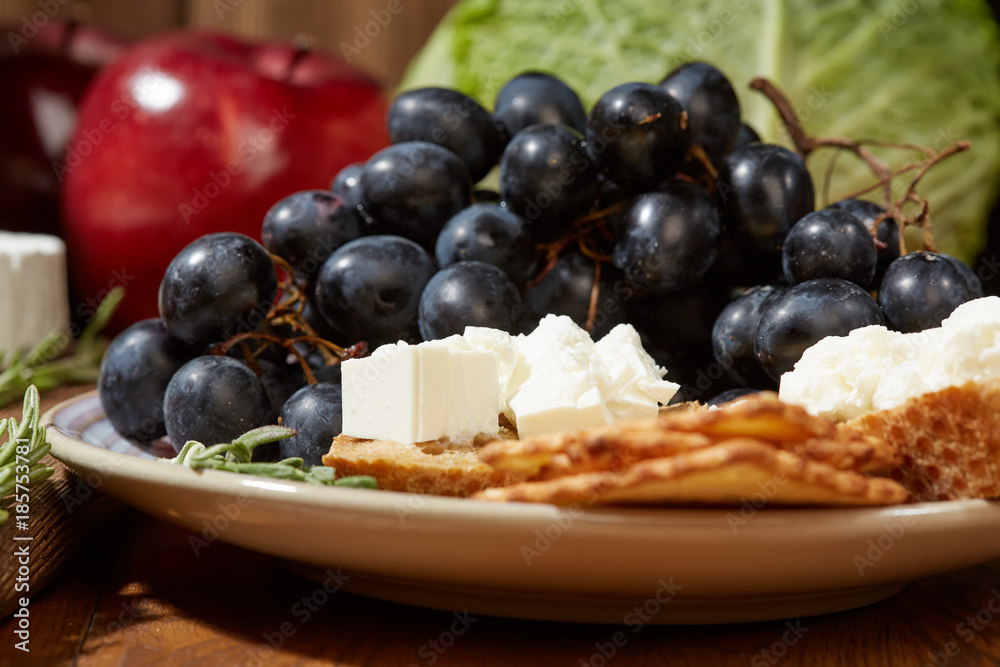 Cheese, vegetables, fruits and spices. Bread, olives and crackers. Mediterranean diet and cuisine. Dark background. Cheese, vegetables, fruits and spices. Bread, olives and crackers. Mediterranean diet and cuisine. Dark background.