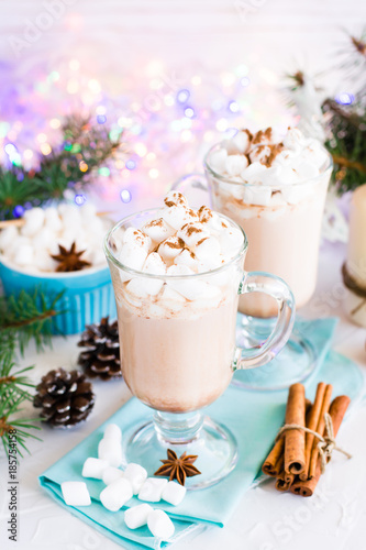 Hot cocoa with marshmallow and ground cinnamon in glasses on the table in Christmas decorations