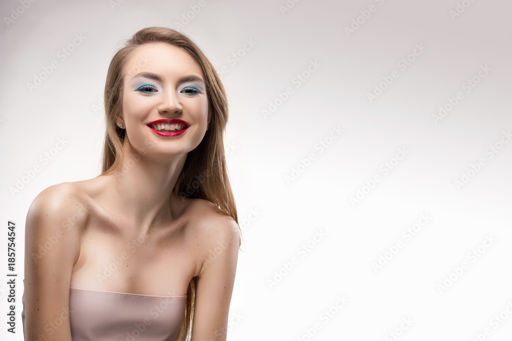 Portrait of the beautiful smiling blonde girl with red lips and red manicure.