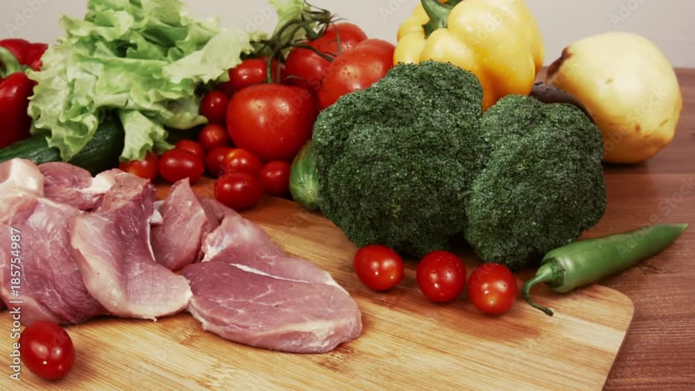 Food sliced pieces of raw meat for barbecue with fresh vegetables on wooden surface. Slices of raw meat and vegetables. Fresh vegetables with raw meat composition isolated on wood table. Food sliced pieces of raw meat for barbecue with fresh vegetables on wooden surface. Slices of raw meat and vegetables. Fresh vegetables with raw meat composition isolated on wood table.