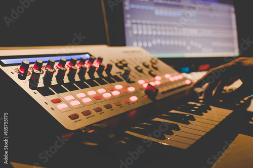 Quadro su tela music producer hands playing midi keyboard synthesizer in recording studio, shallow dept of field