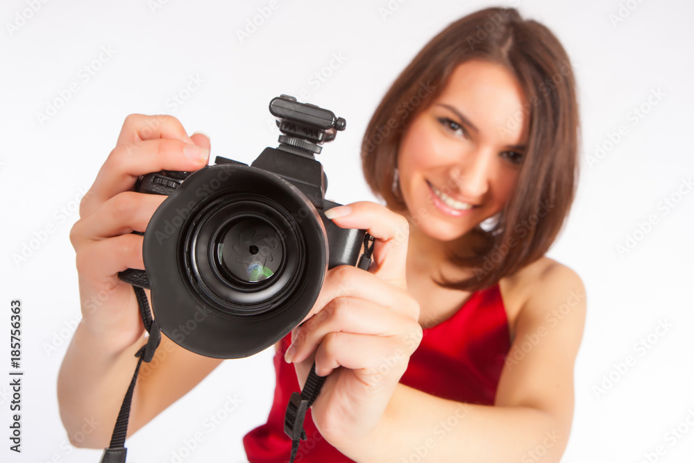 Girl with a camera. The girl is holding a camera. The girl is taking pictures with a smile. Girl with a camera. The girl is holding a camera. The girl is taking pictures with a smile.