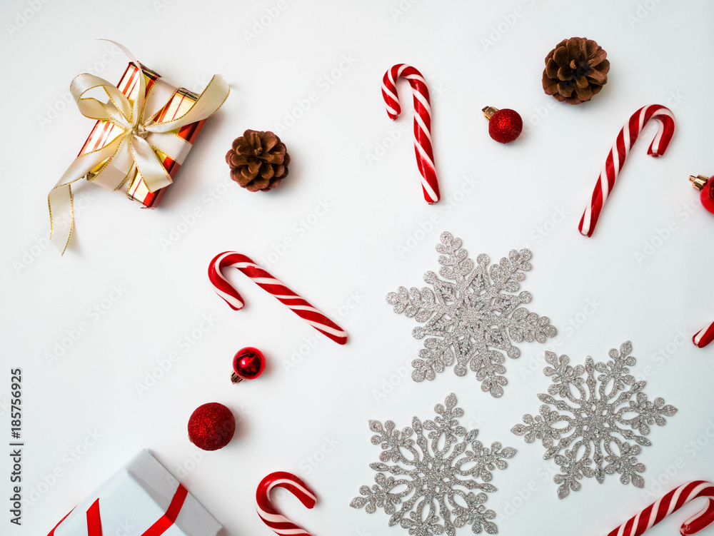 Joyful christmas background. Beautiful present boxes, traditional candy cane lollipops, snowflakes, Santa hat. Preparing for winter holidays concept, top view, copy space Joyful christmas background. Beautiful present boxes, traditional candy cane lollipops, snowflakes, Santa hat. Preparing for winter holidays concept, top view, copy space
