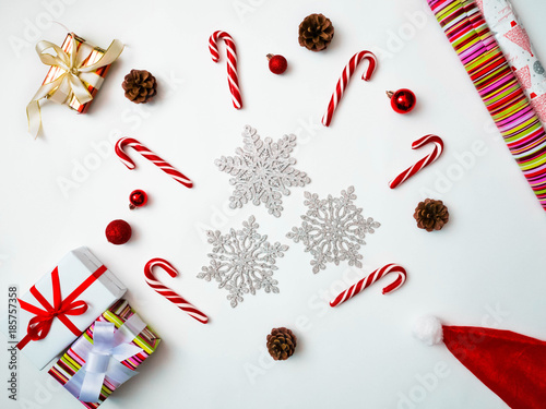 Joyful christmas background. Beautiful present boxes, traditional candy cane lollipops, snowflakes, Santa hat. Preparing for winter holidays concept, top view, copy space
