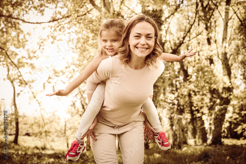 Mother and daughter outdoors in a meadow. On the move.