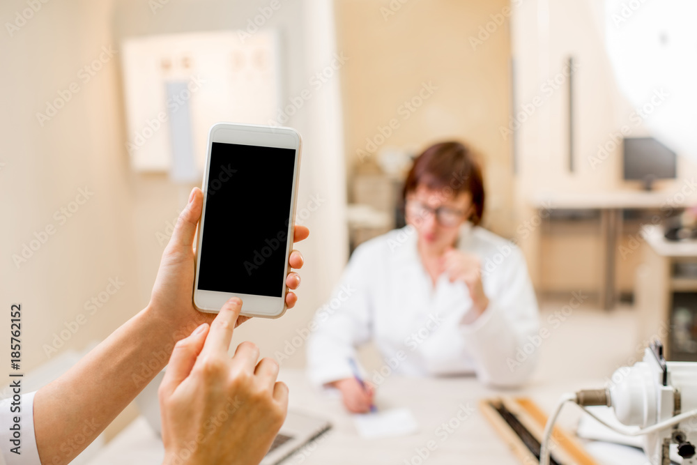 Mockup image of a smart phone on the ophthalmological office background Mockup image of a smart phone on the ophthalmological office background