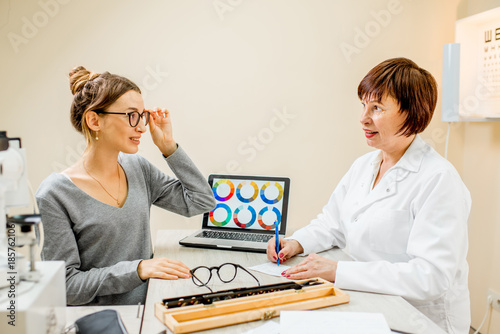 Senior woman ophthalmologist with young female patient during the consultation in the ophthalmological office