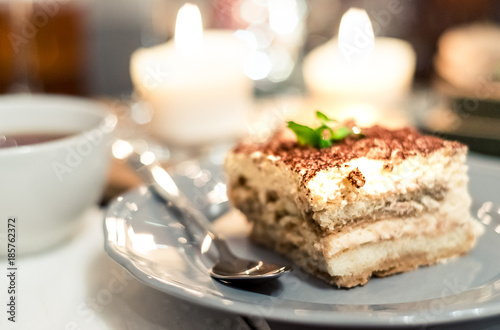 tiramisu by candlelight, romantic date in Italy, tiramisu dessert on a porcelain plate