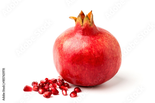 Ripe pomegranate and spill the beans on a white