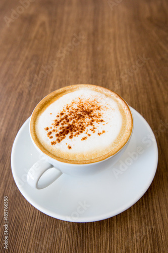 hot cappuccino on wooden table 