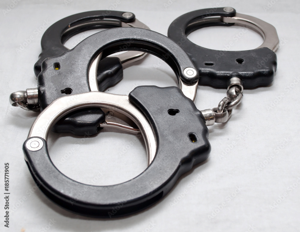 Two pair of handcuffs together on a white background Two pair of handcuffs together on a white background