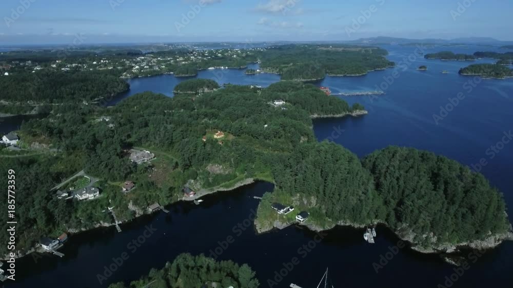 Top view coastline of small fishing city, harbor with great white yachts in Norway. Wonderful blue sea with clear pure water, thick green forest, amazing nature. Solar glare, sunlight. Great seascape Top view coastline of small fishing city, harbor with great white yachts in Norway. Wonderful blue sea with clear pure water, thick green forest, amazing nature. Solar glare, sunlight. Great seascape