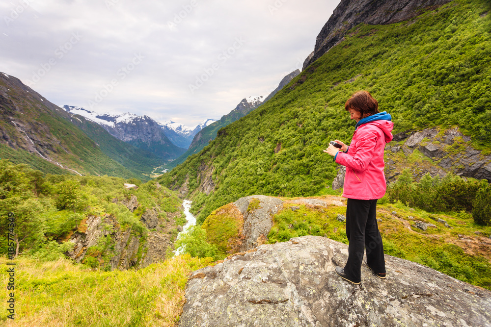 Tourist with camera taking picture in mountains Norway