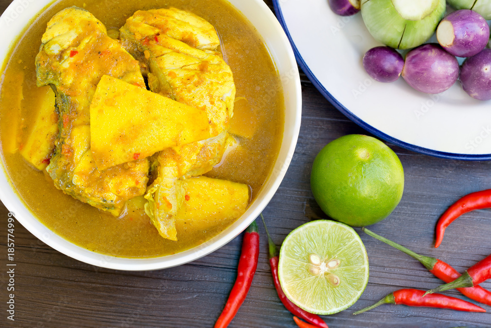 Yellow curry with Snapper fish and coconut shoot in white bow on wooden table Thai food delicious Yellow curry with Snapper fish and coconut shoot in white bow on wooden table Thai food delicious