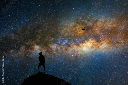 Silhouette of photographer with drone over the milky way on the dark sky background, photographer and transportation with astrophotography concept