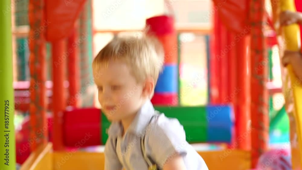 Little boy plays on the Playground with colorful balloons. Dry pool with balls for kids.