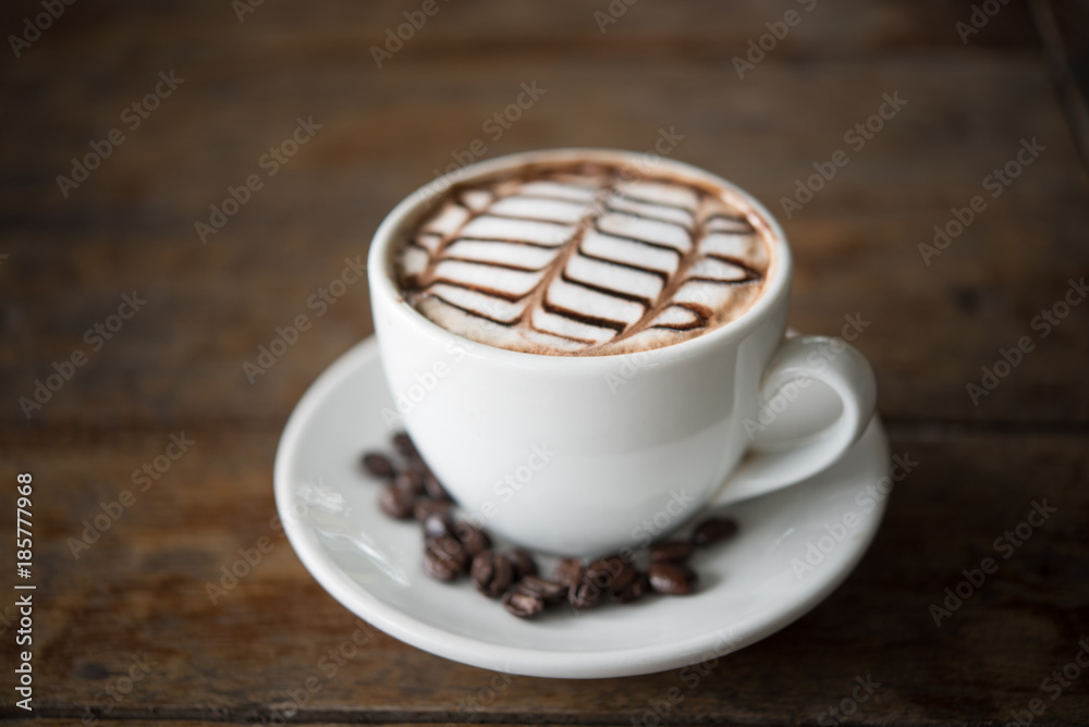 White coffee mug on patterned old wooden floor.
