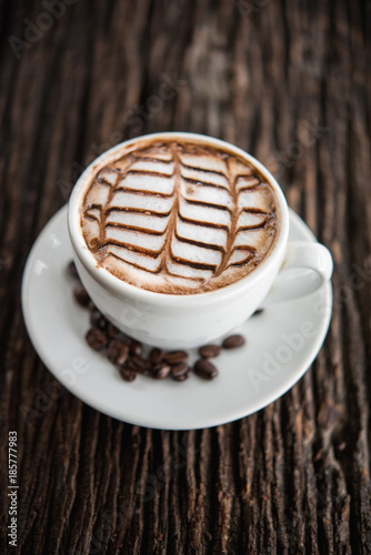 White coffee mug on patterned old wooden floor.