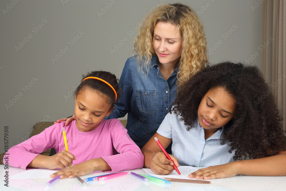 mom watches as her daughter drawing with crayons. mom watches as her daughter drawing with crayons.