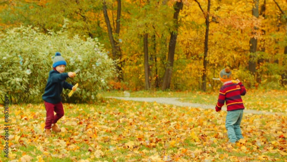 Little boys are blowing bubbles in the autumn park Little boys are blowing bubbles in the autumn park