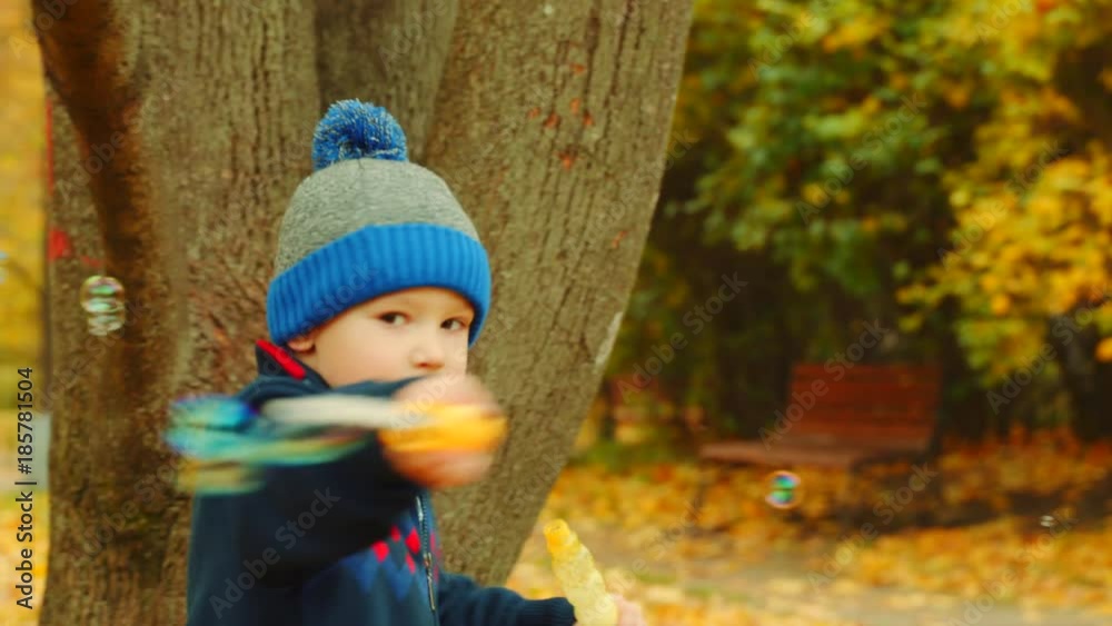 Little boys are blowing bubbles in the autumn park Little boys are blowing bubbles in the autumn park