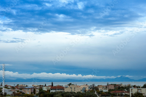 Mediterranean town on a background of blue sea and sky with clouds