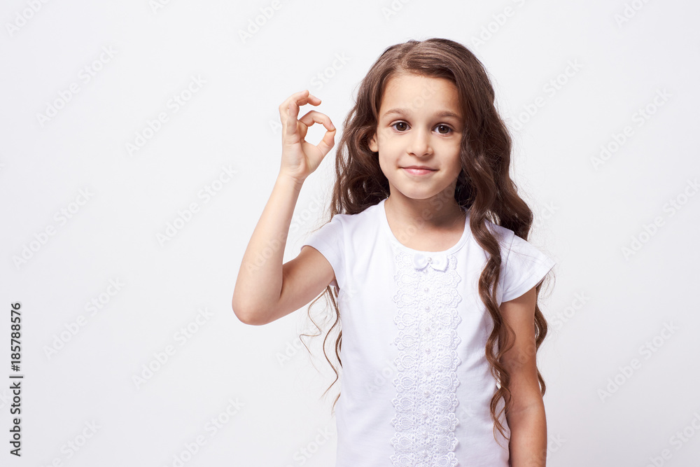 Gesture approval. Little girl. White background. Brunette Gesture approval. Little girl. White background. Brunette